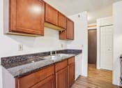 Thumbnail 35 of 37 - A kitchen with brown cabinets and a granite counter top.