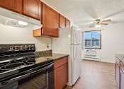 Thumbnail 31 of 37 - A kitchen with a black stove top oven and a white refrigerator.