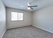 Thumbnail 30 of 31 - A room with a ceiling fan and a window with blinds.