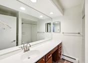 Thumbnail 65 of 66 - A bathroom with a sink, mirror, and shower.