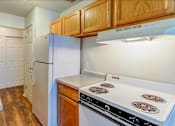 Thumbnail 29 of 34 - A kitchen with a white stove top oven and a white refrigerator.