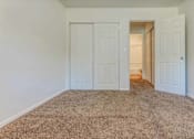 Thumbnail 27 of 34 - A room with a carpeted floor and two white doors.