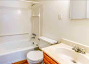 Thumbnail 32 of 34 - A white bathroom with a toilet, sink, and bathtub.
