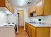 Thumbnail 14 of 34 - A kitchen with wooden cabinets and a white countertop.