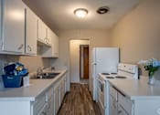 Thumbnail 31 of 31 - A kitchen with white appliances and cabinets.