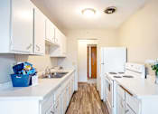 Thumbnail 2 of 31 - A kitchen with white appliances and cabinets.
