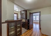 Thumbnail 27 of 27 - A white refrigerator is in the corner of a room with wood floors and white walls.