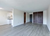 Thumbnail 41 of 41 - A spacious room with wooden flooring and white walls.