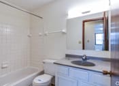 Thumbnail 40 of 41 - A white bathroom with a toilet, sink, and bathtub.
