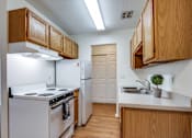 Thumbnail 2 of 34 - A kitchen with white appliances and wooden cabinets.