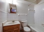 Thumbnail 31 of 34 - A white bathroom with a toilet, sink, and bathtub.