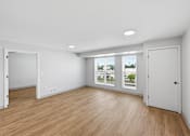 Thumbnail 44 of 54 - A room with wooden floors and white walls.