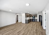 Thumbnail 42 of 54 - A spacious kitchen with wooden floors and white walls.