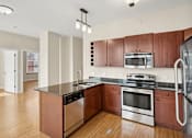 Thumbnail 18 of 68 - an empty kitchen with wooden cabinets and stainless steel appliances