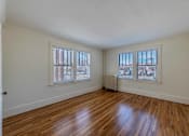 Thumbnail 9 of 27 - A room with wooden floors and white walls.
