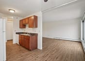 Thumbnail 28 of 37 - A kitchen with wooden floors and white walls.