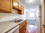 Thumbnail 16 of 34 - A kitchen with wooden cabinets and a white dishwasher.