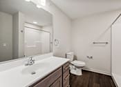 Thumbnail 19 of 43 - a bathroom with a large mirror and a toilet and sink