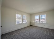 Thumbnail 24 of 27 - A room with a grey carpet and a window with blinds.