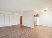 Thumbnail 26 of 37 - A room with a ceiling fan and wooden floors.