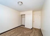 Thumbnail 24 of 34 - A room with a carpeted floor and two doors.