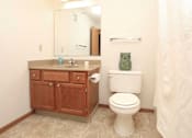 Thumbnail 22 of 38 - A white toilet sits next to a sink in a bathroom.