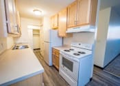 Thumbnail 22 of 34 - A kitchen with white appliances and wooden cabinets.