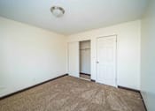 Thumbnail 28 of 34 - A room with a carpeted floor and two doors.