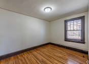 Thumbnail 25 of 27 - A room with wooden floors and a window with blinds.