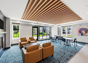 Thumbnail 10 of 54 - A modern office lounge with orange chairs and a wooden ceiling.