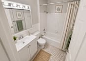 Thumbnail 9 of 20 - A white bathroom with a toilet, sink, and shower.
