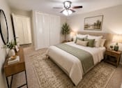 Thumbnail 15 of 20 - A bedroom with a large bed, a ceiling fan, and a painting on the wall.