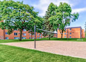 Thumbnail 8 of 34 - A volleyball net stands in the middle of a sandy court.