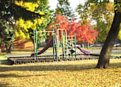 Thumbnail 34 of 34 - A playground with a green slide and a red slide.