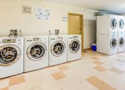 Thumbnail 13 of 34 - A row of washing machines in a laundry room.