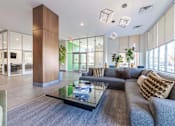 Thumbnail 1 of 30 - A modern living room with a grey couch and a glass coffee table.