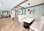 Thumbnail 26 of 27 - A room with a white table and chairs with a wooden floor and a wall with a painting on it.