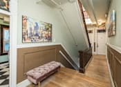 Thumbnail 3 of 12 - A staircase with a bench and a painting on the wall.