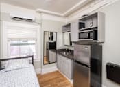 Thumbnail 5 of 12 - A small kitchen with a bed in the corner.