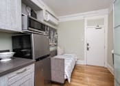 Thumbnail 4 of 12 - A kitchen with a refrigerator, microwave, and oven.
