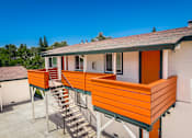 Thumbnail 2 of 16 - A house with orange wooden balconies and a grey roof.