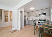 Thumbnail 12 of 16 - A kitchen with a table and chairs in it.