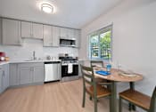 Thumbnail 1 of 16 - A kitchen with a table and chairs.