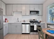 Thumbnail 9 of 16 - A kitchen with a stainless steel refrigerator, oven, and microwave.