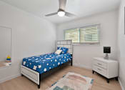 Thumbnail 13 of 16 - A bedroom with a bed, nightstand, and a rug on the floor.