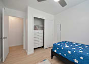 Thumbnail 15 of 16 - A bedroom with a bed, dresser, and wardrobe.