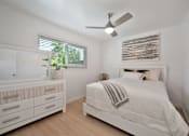 Thumbnail 14 of 16 - A white bedroom with a bed, dresser, and mirror.