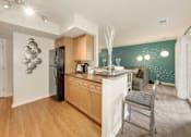 Thumbnail 3 of 32 - A kitchen with a black refrigerator and wooden cabinets.