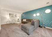 Thumbnail 1 of 32 - A living room with a grey sofa and a white coffee table.