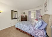 Thumbnail 22 of 32 - A bedroom with a bed, nightstand, and lamp.